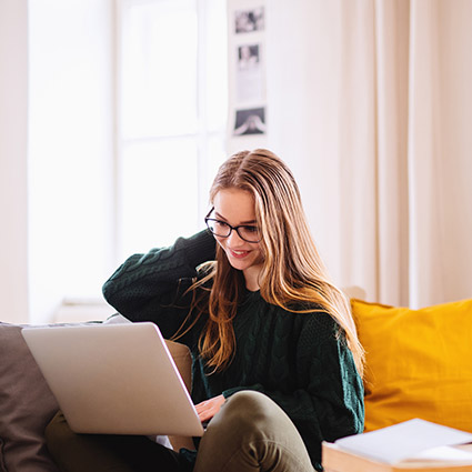 Young woman working on laptop in living room