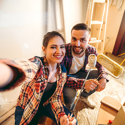 Young couple painting living room