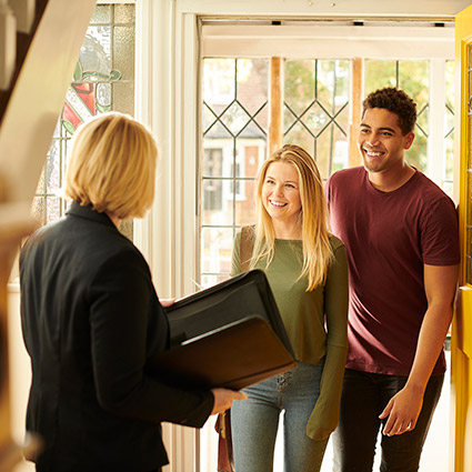 Young couple and realtor looking at house