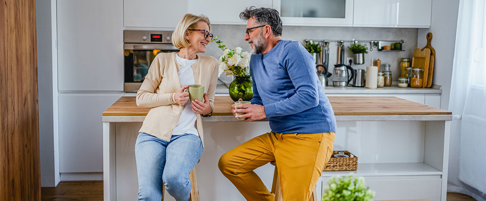 Mature couple enjoying a drink in the kitchen